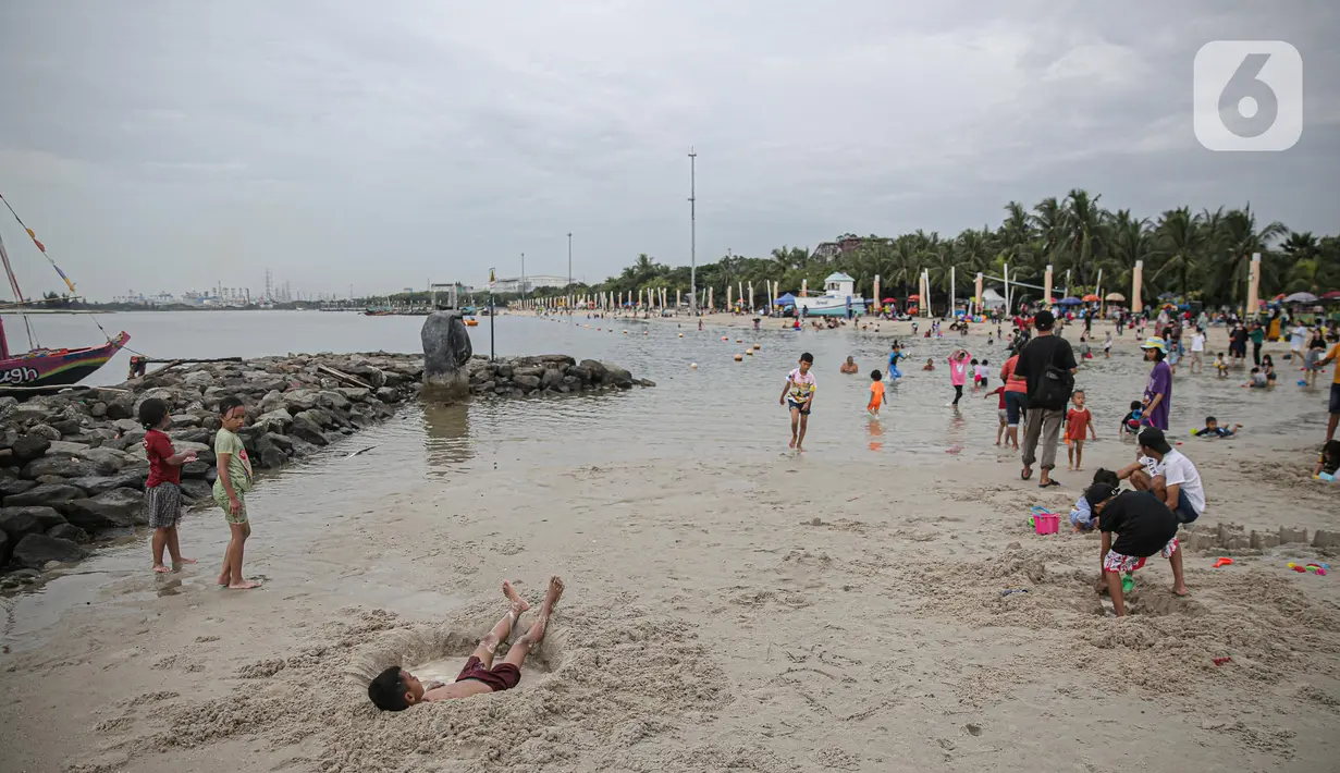 Pengujung berwisata di Pantai Ancol, Jakarta, Rabu (28/12/2022). Isu cuaca yang kurang bersahabat pada hari ini, tidak menyurutkan keinginan warga menghabiskan libur untuk berwisata di kawasan wisata Ancol. (Liputan6.com/Faizal Fanani)