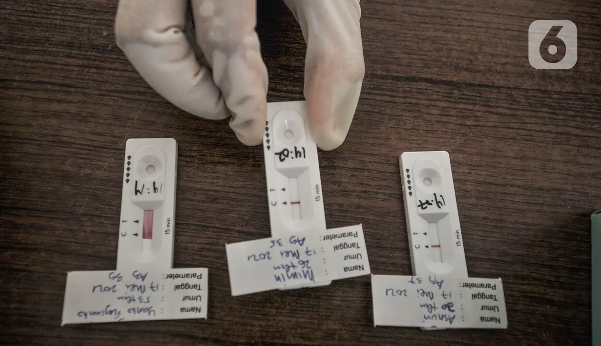 Petugas memperlihatkan hasil pemeriksaan tes cepat Antigen COVID-19 di GOR Kecamatan Makasar, Jakarta Timur, Senin (17/5/2021). Hari ini tercatat sebanyak 71 warga yang diundang oleh RT di wilayah masing-masing menjalani tes Covid-19, baik tes antigen maupun PCR. (merdeka.com/Iqbal S Nugroho)