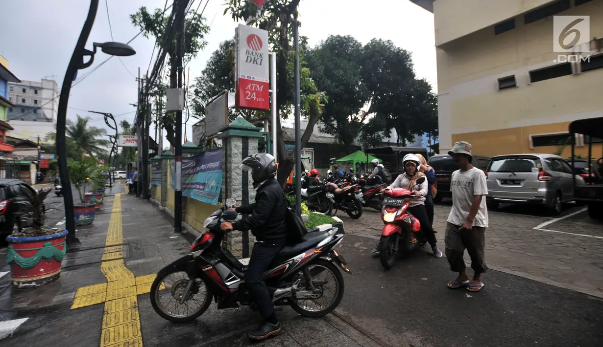 Pegawai kantor Balai Kota DKI Jakarta mengambil motor yang diparkir di halaman Kelurahan Kebon Sirih, Jakarta, Rabu (16/1). Naiknya tarif parkir di IRTI Monas juga menyebabkan halaman Kelurahan tersebut dipenuhi sepeda motor. (Merdeka.com/Iqbal S Nugroho)