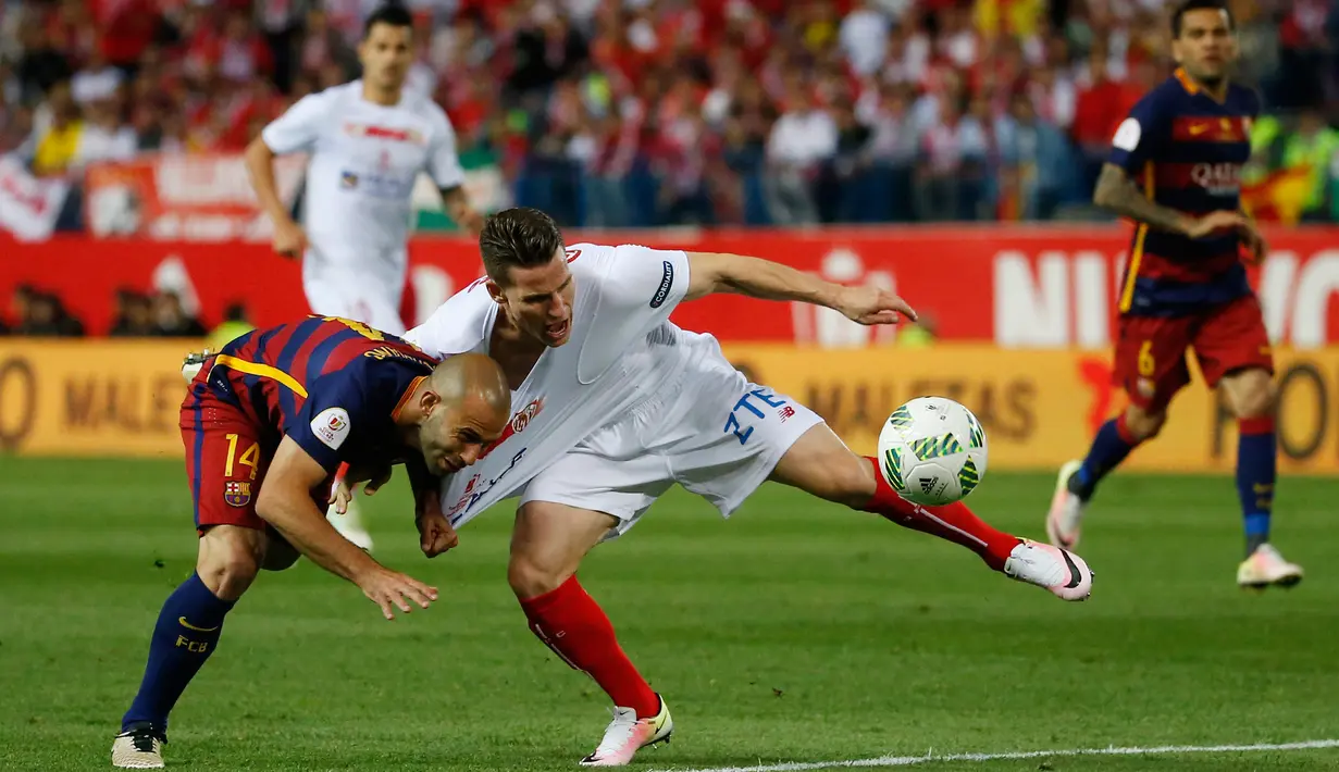 Gelandang Barcelona, Javier Mascherano berebut bola dengan penyerang Sevilla, Kevin Gameiro saat pertandingan final Piala Copa del Rey di Madrid, (23/5). Barcelona menang atas Sevilla dengan skor 2-0. (Reuters / Juan Medina)