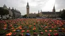 Jaket pelampung dipajang seperti sebuah pemakaman umum di dekat Gedung Parlemen London, Senin (19/9).  Sebanyak 2.500 jaket pelampung yang usang ini pernah dipakai para pengungsi yang menyebrang dari Turki ke Pulau Chios, Yunani. (Daniel Leal-Olivas/AFP)