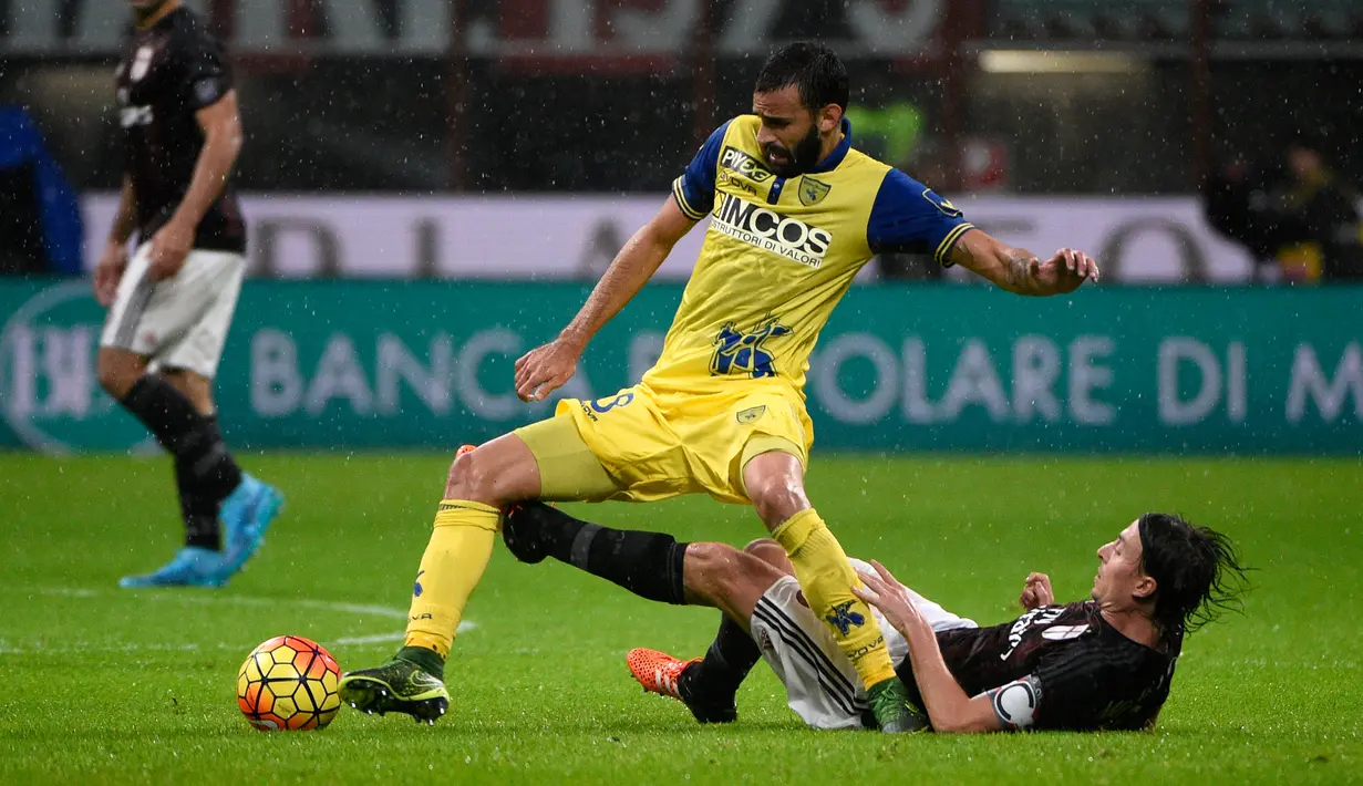 Gelandang AC Milan, Riccardo Montolivo (kanan) berusaha merebut bola yang di bawa gelandang Chievo, Giampiero Pinzi pada laga serie A di stadion San Siro, Italia (28/10/2015). AC Milan menang atas Chievo dengan skor 1-0. (AFP PHOTO/OLIVIER MORIN)
