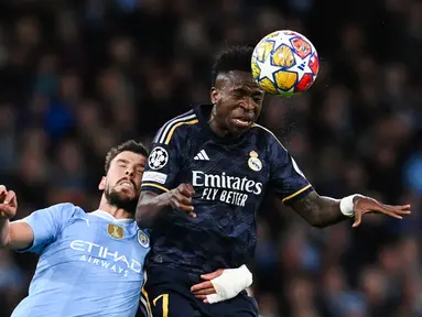 Penyerang Manchester City Erling Haaland berebut bola dengan bek Real Madrid Nacho dalam duel leg kedua perempat final Liga Champions 2023/2024, di Etihad Stadium, Kamis (18/4/2024) dini hari WIB. (Paul ELLIS / AFP)