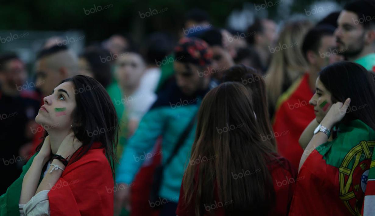Suporter wanita Portugal cemas menanti gol dari Cristiano Ronaldo dan kawan-kawan saat melawan Kroasia pada laga 16 besar Piala Eropa 2016 saat nonton bareng di Fan Zone Kota Paris, Prancis, Sabtu (25/6/2016). (Bola.com/Vitalis Yogi Trisna)