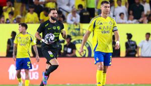 Pemain depan Nassr asal Portugal #7, Cristiano Ronaldo, bereaksi saat pemain depan Ittihad asal Prancis #09 Karim Benzema merayakan gol pertama timnya selama pertandingan sepak bola Liga Pro Saudi antara Al-Nassr dan Al-Ittihad di Taman Al-Awwal di Riyadh, Kamis dini hari WIB (8-5-2025). (Fayez NURELDINE/AFP)