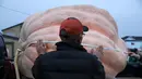 Pekerja mengukur labu raksasa dalam lomba Safeway World Championship Pumpkin Weigh-Off di Half Moon Bay, California, Amerika Serikat, Senin (14/10/2019). Seorang petani keluar sebagai juara dengan labu seberat 2.175 pon miliknya. (Justin Sullivan/Getty Images/AFP)