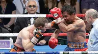 Petinju Filipina, Manny Pacquiao, menangkis pukulan petinju Australia, Jeff Horn pada perebutan sabuk juara kelas welter versi WBO di Stadion Suncorp, Brisbane, Minggu (2/7). Horn mengalahkan Pacquiao dalam pertarungan 12 ronde. (AP/Tertius Pickard)