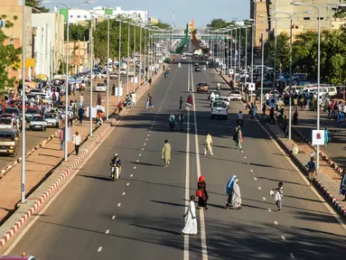 Orang-orang melintasi jalanan di Niamey, Niger (10/7/2019). Niamey adalah ibu kota sekaligus kota terbesar Niger. Penduduknya berjumlah 800,000 jiwa (2000) dengan luas wilayah 670 km².  (AFP Photo/Issouf Sanogo)