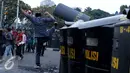 Seorang mahasiswa menendang tameng polisi yang berjaga saat unjuk rasa di Jalan Medan Merdeka Barat, Jakarta, Kamis (20/10). Mahasiswa menagih janji Nawacita pemerintahan Jokowi-JK. (Liputan6.com/Gempur M Surya)