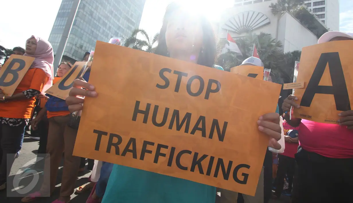 Peserta aksi damai membawa poster bertuliskan 'Stop Human Trafficking' di kawasan Bundaran HI, Jakarta, Minggu (18/12). Aksi yang digelar PRT Migran tersebut dalam rangka memperingati Hari Migran Internasional 2016. (Liputan6.com/Immanuel Antonius)