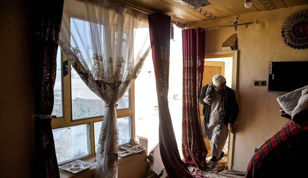 Seorang penyintas gempa bumi Afghanistan melihat sisa-sisa rumah yang rusak di sebuah desa di Tashqurghan, distrik Khulm, provinsi Samangan, pada Senin 3 November 2025. Hal tersebut diungkap Juru bicara Kementerian Kesehatan pemerintah Taliban Sharafat Zaman Amar pada Senin 3 November 2025. (Atif Aryan/AFP)