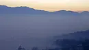 Menara masjid tampak tertutup oleh kabut asap yang tebal di desa Ponijeri, Kota Sarajevo, Bosnia dan Herzegovina, Minggu (27/12). Pemerintah setempat mengimbau warganya untuk tidak beraktivitas di luar rumah. (REUTERS/Dado Ruvic)