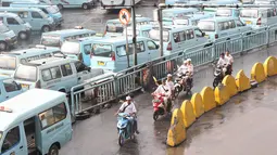 Pengendara sepeda motor melintasi jalur angkutan umum di Terminal Kampung Melayu, Jakarta, Rabu (6/2). Meskipun terdapat larangan melintas bagi pemotor, namun masih ada sejumlah pengendara nekat menerobos masuk terminal. (Liputan6.com/Immanuel Antonius)