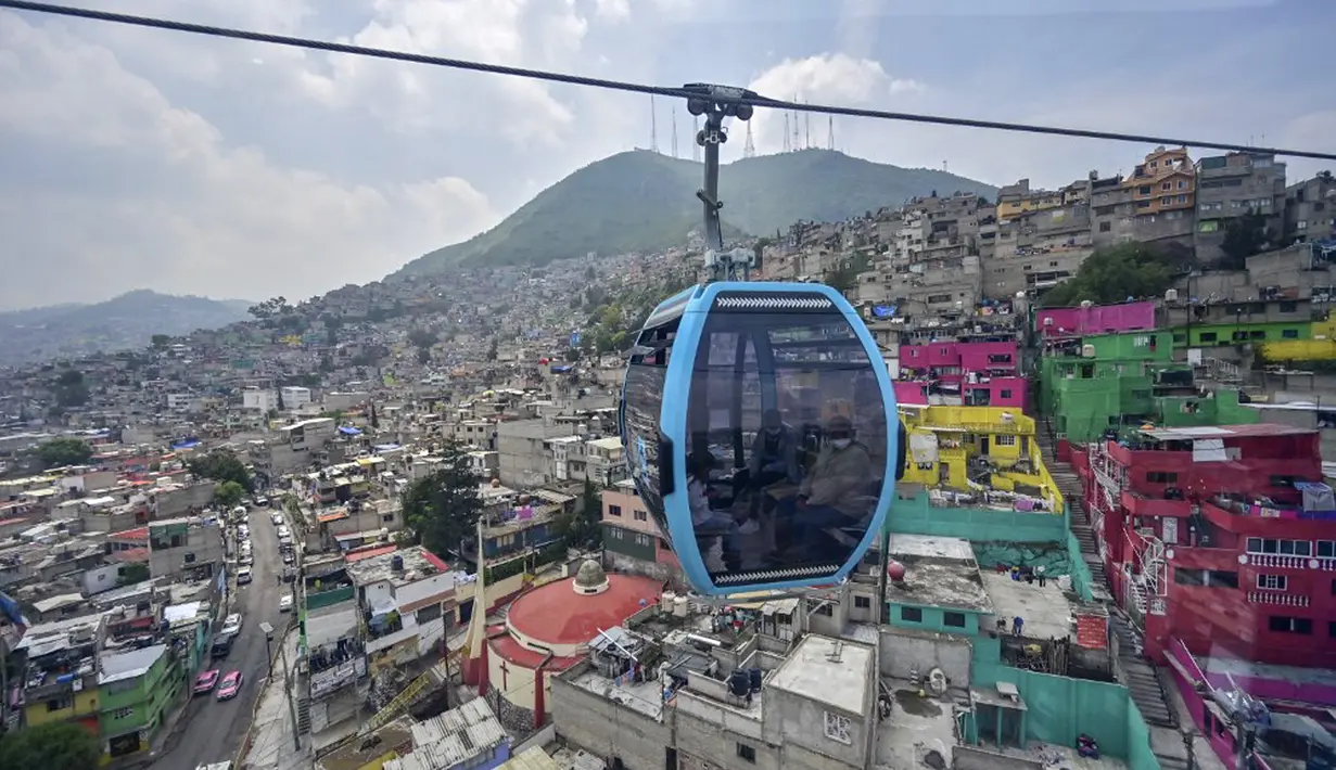 Penumpang melakukan perjalanan dengan sistem kereta gantung yang dijuluki Cablebus setelah peresmiannya di pinggiran Mexico City, Meksiko, 12 Juli 2021. Mexico City mulai mengoperasikan sistem kereta gantung yang menjanjikan untuk menghemat waktu bagi ribuan pengguna. (PEDRO PARDO/AFP)