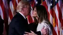 Presiden ke-45 AS, Donald Trump mencium istrinya, Melania usai menyampaikan pidato kemenangan di Manhattan, New York Rabu (9/11). Trump berhasil mendapat suara electoral votest lebih dari 270, sebagai syarat kemenangan Pilpres AS. (REUTERS/Jonathan Ernst)