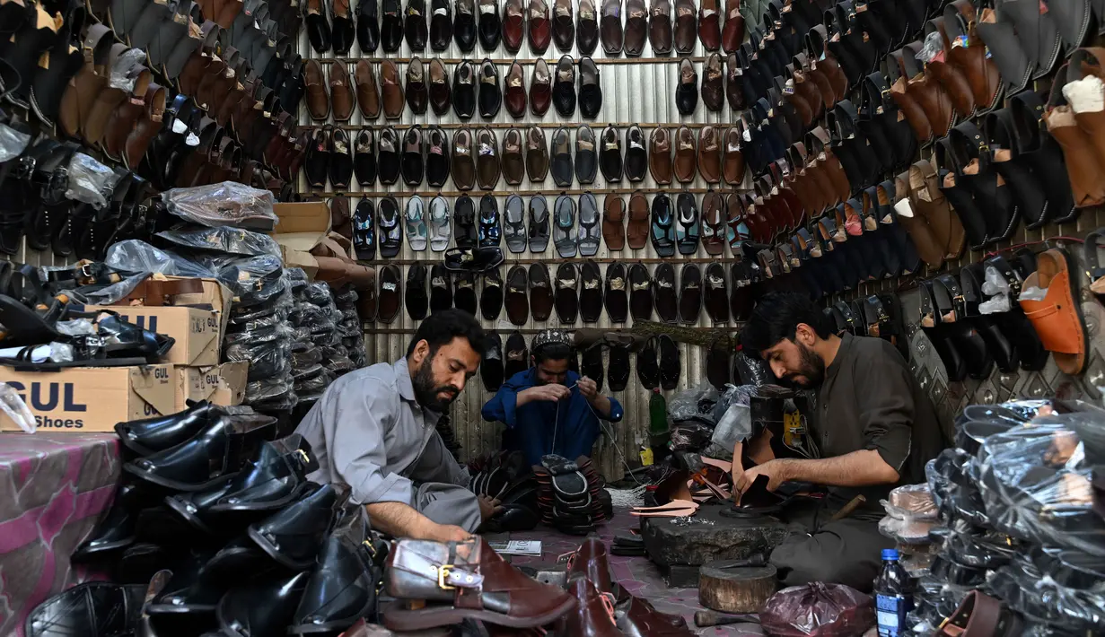 Di sisi lain, kesibukan juga terjadi di salah satu bengkel perajin sepatu tradisional di Lahore, Pakistan. Tampak dalam foto, aktivitas para perajin sepatu membuat sandal di sebuah bengkel menjelang perayaan Idul Fitri selama bulan suci Ramadan 1447 Hijriah di Lahore pada 14 Maret 2026. (Arif ALI/AFP)