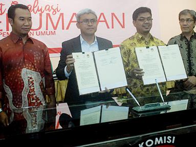 Ketua KPU Pusat Juri Ardiantoro (kedua kanan) dan Ketua Komisi informasi Publik John Fresly (ketiga kiri) menunjukkan nota kesepakatan di Gedung KPU, Jakarta, Selasa (29/11).  (Liputan6.com/Helmi Afandi)