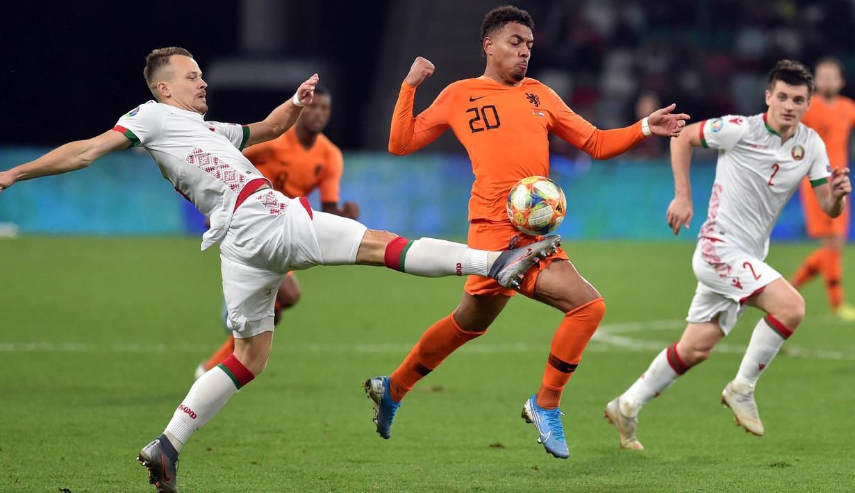 Striker Belanda, Donyell Malen, berusaha melewati bek Belarusia, Denis Polyakov, pada laga Kualifikasi Piala Eropa 2020 di Minsk, Minggu (13/10). Belarusia kalah 1-2 dari Belanda. (AFP/Sergei Gapon)