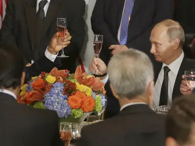 Presiden Rusia, Vladimir Putin (kanan) dan Presiden AS, Barack Obama bersulang saat jamuan makan siang pada acara Sidang Umum PBB di New York, Senin (28/9/2015). (REUTERS/Mikhail Metzel/RIA Novosti/Pool)