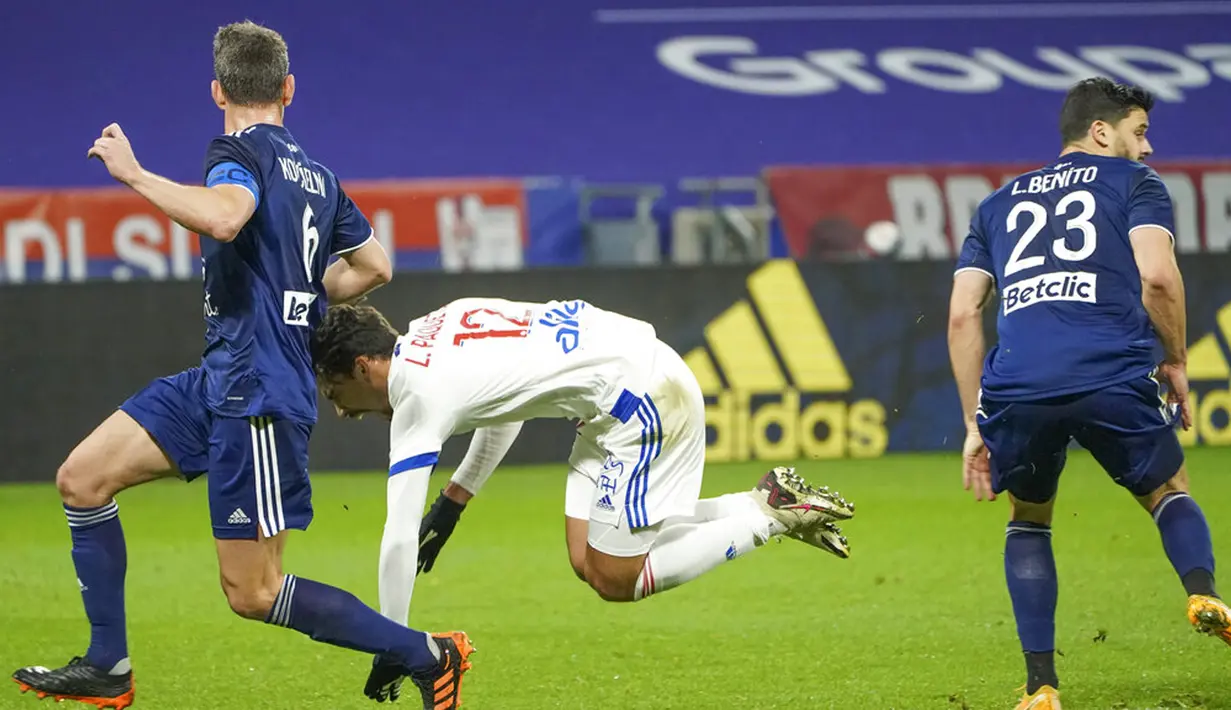 Pemain Lyon Lucas Paqueta (tengah) bereaksi saat ia bertarung memperebutkan bola dengan pemain Bordeaux Laurent Koscielny (kiri) dan Loris Benito (kanan) pada pertandingan Liga Prancis di Lyon, Prancis, Jumat (29/1/2021). Lyon menang 2-1 atas Bordeaux. (AP Photo/Laurent Cipriani)