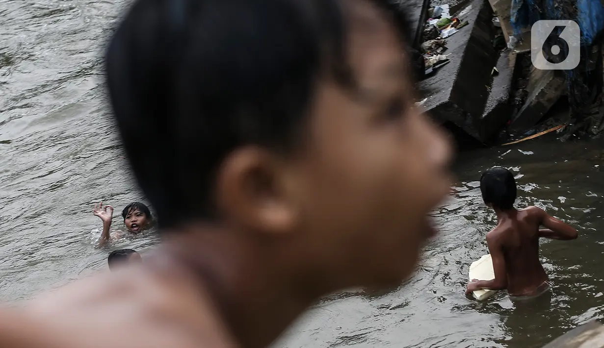 Anak-anak berenang di Sungai Ciliwung, Jakarta, Selasa (24/8/2021). Sungai Ciliwung menjadi tempat alternatif untuk bermain di kala pandemi karena ditutupnya ruang-ruang bermain atau taman kota, dan juga karena kurangnya ruang bermain bagi anak-anak. (Liputan6.com/Johan Tallo)