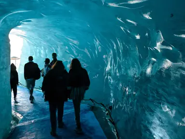 Wisatawan mengunjungi sebuah gua es yang dikenal dengan "La Grotte de Glace", di gletser Mer de Glace (Lautan Es) di Chamonix-Mont-Blanc, Pegunungan Alpen Prancis, Jumat (19/7/2019). Gua yang berada di lereng Mont Blanc ini memiliki panjang 7 km dengan kedalaman 200 meter. (PHILIPPE DESMAZES/AFP)