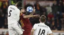 Bek Real Madrid, Raphael Varane, duel udara dengan bek AS Roma, Federico Fazio, pada laga Liga Champions di Stadion Olimpico, Roma, Selasa (27/11). AS Roma takluk 0-2 dari Real Madrid. (AP/Andrew Medichini)