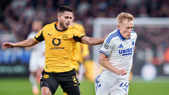 Pemain Borussia Dortmund, Yan Couto (kiri), berebut bola dengan pemain Copenhagen, Birger Meling