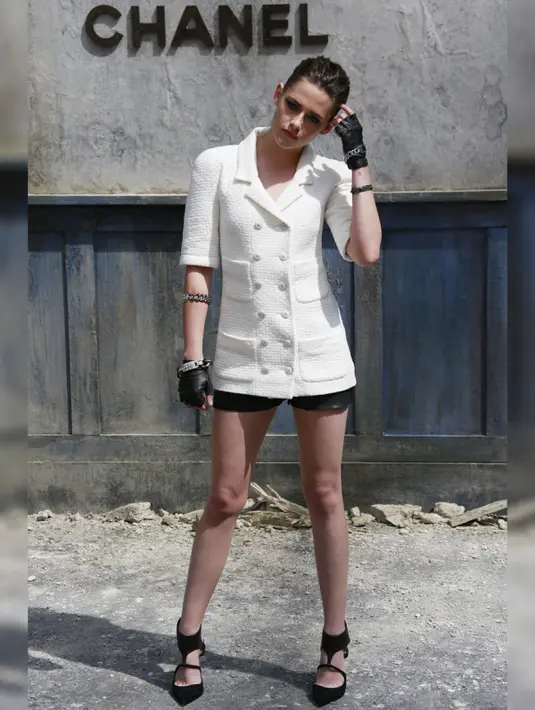Saat Kristen Stewart hadir di acara Chanel Paris Fashion Show, ia terlihat sangat cantik dengan memakai Blazer putih karya Chanel yang di padukan dengan celana pendek hitam dan wedges hitam.  (www.ibtimes.co.uk)