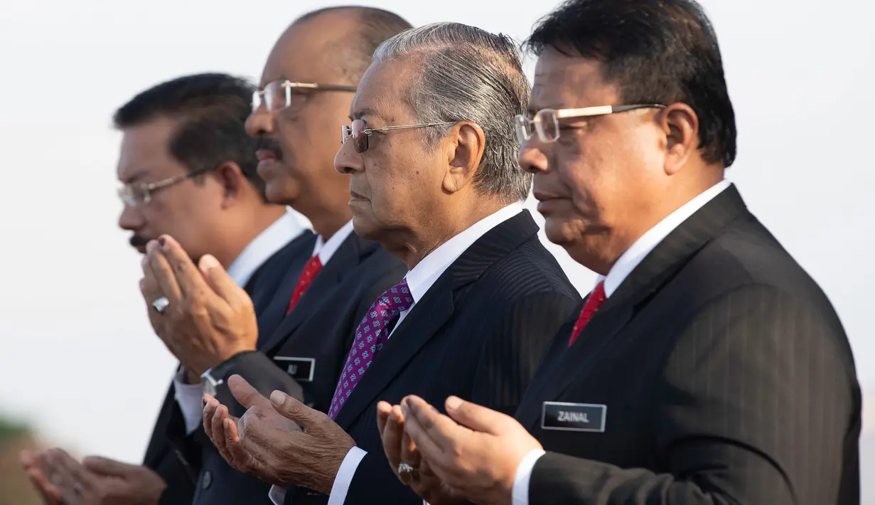 PM baru Malaysia Mahathir Mohamad berdoa saat menghadiri pertemuan bulanan pertamanya di Putrajaya, Malaysia (21/5). Kabinet pemerintahan Malaysia di bawah komando PM Mahathir Mohamad resmi dilantik pada Senin (21/5). (AP/Vincent Thian)