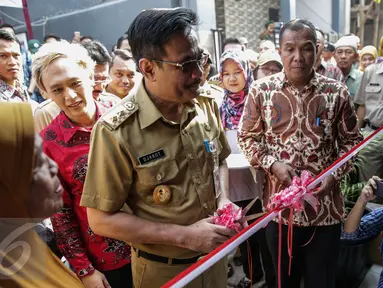 Wagub DKI Jakarta, Djarot Saiful bersiap memotong pita saat meresmikan program bedah rumah di Cilincing, Jakarta, Senin (17/4). Dalam pendataan ada 83 rumah warga yang tak layak huni sudah masuk dalam program bedah rumah. (Liputan6.com/Faizal Fanani)