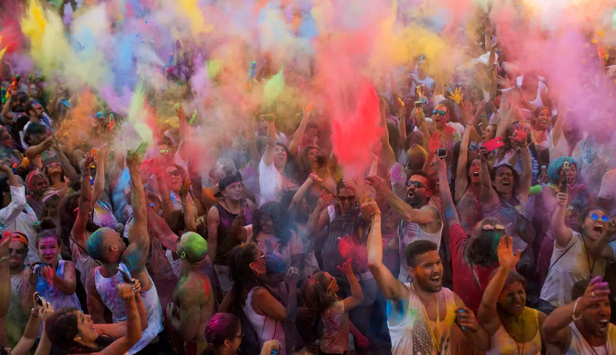 Kecerian para peserta saat mengikuti Festival Monsoon Holi di Madrid, Spanyol (5/8). Kini, festival Holi bukan saja dilakukan oleh warga India dan Nepal tetapi sudah menjadi tren di sejumlah negara. (AP Photo/Francisco Seco)