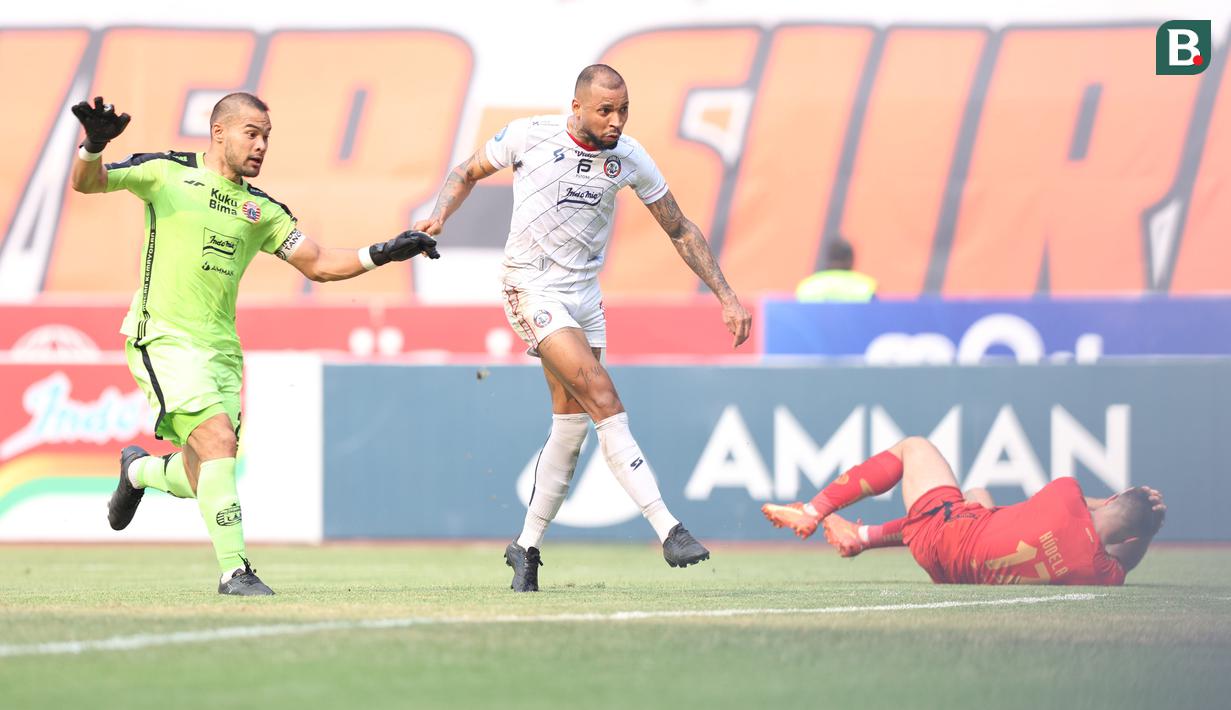 Pemain Arema FC, Gustavo Almeida, mencetak gol, sementara pemain Persija Jakarta, Ondrej Kudela, terkapar sambil memegang kepalanya pada lanjutan BRI Liga 1 2023/2024 di Stadion Patriot Chandrabhaga, Kota Bekasi, Minggu (20/08/2023). Kedua tim bermain imbang 2-2. (Bola.com/M Iqbal Ichsan)