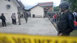 Sejumlah polisi bersenjata disiagakan disekitar RS Bhayangkara Palu, Sulawesi Tengah, Selasa (17/7). Dua jenazah diduga teroris Santoso alias Abu Warda dan Muhtar yang tewas dalam baku tembak tiba di RS tersebut untuk diidentifikasi. (OLAGONDRONK/AFP)