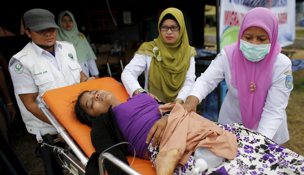 Petugas kesehatan saat memindahkan seorang wanita etnis Rohingya di tempat penampungan, Kuala Langsa, Aceh (25/5/2015). Pemerinta RI mengalokasikan bantuan sebesar Rp 2,3 Miliar untuk pengungsi Rohingya yang berada di Aceh. (Reuters/Darren Whiteside)