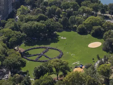 Ribuan orang mencoba memecahkan rekor dunia untuk rantai manusia terpanjang dalam bentuk tanda perdamaian di New York Central Park, Selasa (6/10). Kegiatan itu menandai ulang tahun John Lennon ke-75. (REUTERS/NYonAir/Paul GaNun)