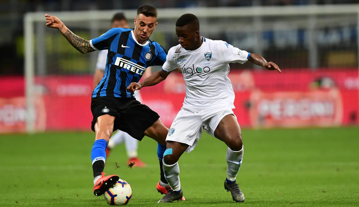 Bek Inter Milan, Matias Vecino berebut bola dengan pemain Empoli, Hamed Junior Traore pada pertandingan pekan ke-38 Serie A di Giuseppe Meazza, Minggu (26/5/2019). Inter Milan akhirnya lolos ke Liga Champions musim depan setelah bersusah payah menyegel kemenangan 2-1 atas Empoli. (Miguel MEDINA/AFP)