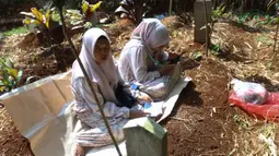 Usai melaksanakan Salat Idulfitri 1447 Hijriah/2026 Masehi, sebagian umat muslim memadati salah satu Tempat Pemakaman Umum (TPU), Cibinong, Kabupaten Bogor, Jawa Barat. Tampak dalam foto, warga saat melakukan ziarah kubur usai melaksanakan salat Idulfitri 1447 Hijriah di salah satu Tempat Pemakaman Umum (TPU), Cibinong, Kabupaten Bogor, Jawa Barat, Sabtu (21/3/2026). (Kapanlagi.com/Budy Santoso)