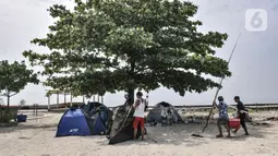 Wisatawan mendirikan tenda di Pulau Kelor, Kepulauan Seribu, Jakarta, Minggu (11/4/2021). Pariwisata Kepulauan Seribu mulai ramai dikunjungi wisatawan setelah beberapa waktu lalu Pemprov DKI membuka kembali seiring menurunnya kasus Covid-19. (merdeka.com/Iqbal S Nugroho)