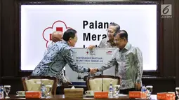 Presdir PT Astra International Tbk Prijono Sugiarto berjabat tangan dengan Ketua Umum PMI Jusuf Kalla pada acara penyerahan bantuan 10 unit truk tangki air di Kantor PMI, Jakarta, Jumat (8/2). (Liputan6.com/Fery Pradolo)