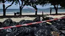 Tumpukan kantong plastik berisi sampah di tepi sebuah pantai di Hong Kong, Senin (7/8). Kecelakaan kapal pengangkut minyak sawit di perairan sekitar Hong Kong memaksa negara di bawah kedaulatan China itu menutup 10 pantainya. (Anthony WALLACE / AFP)