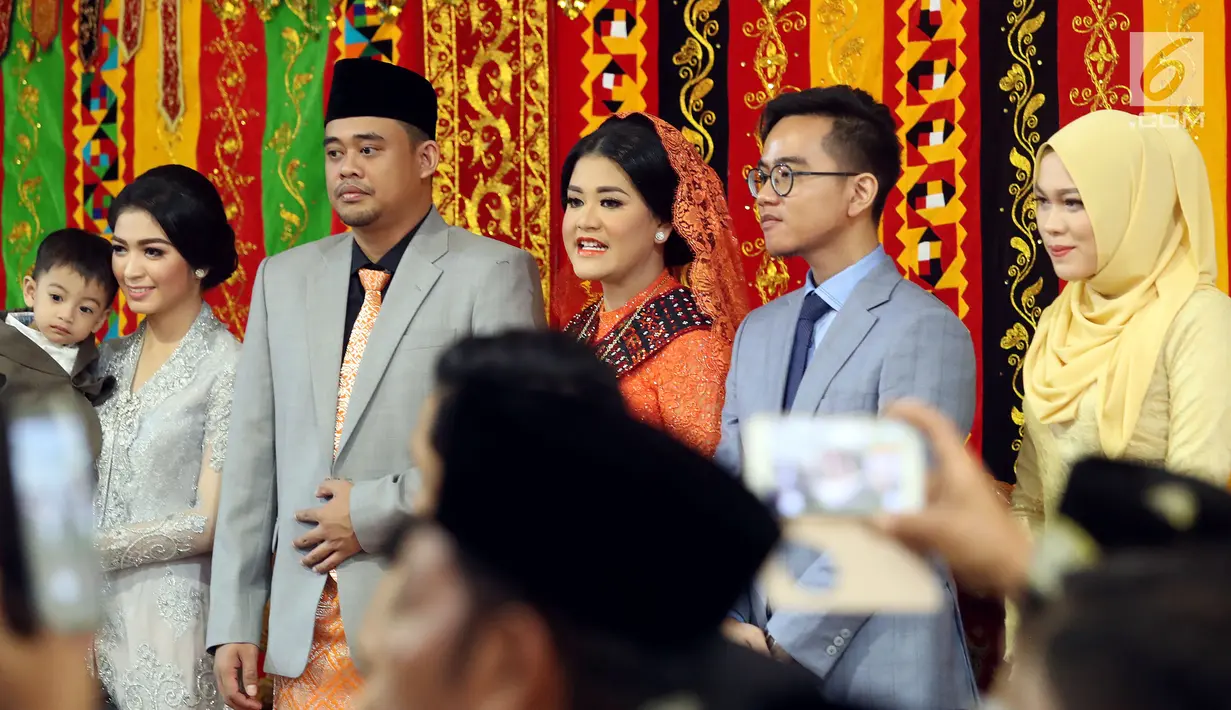Kahiyang Ayu dan Bobby Nasution didampingi kakaknay, Gibran Rakabuming serta Selvi Ananda pada pesta adat pernikahan di Kompleks BHR-Tasbi, Medan, Jumat (24/11). Kahiyang dan Bobby kompak mengenakan pakaian nuansa oranye. (Liputan6.com/Pool/Media Center)