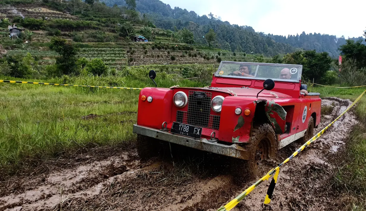 Mobil Land Rover menerobos jalan berlumpur pada acara kamping bersama di kaki gunung Gede Pangrango, Bogor, Jawa Barat, Minggu (23/12). Acara yang digelar selama 3 hari diikuti sekitar 800 mobil se Indonesia dan luar negeri. (Liputan6.com/Pool/ILRU)