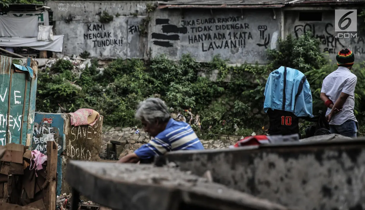 Sejumlah mural hiasi dinding rumah yang terkena penertiban di kawasan bantaran Kali Ciliwung, Kelurahan Bukit Duri, Tebet, Jakarta, Selasa (11/7). Semuanya terpusat di RT 001, 002, 003, dan 004, RW 12 Kelurahan Bukit Duri. (Liputan6.com/Faizal Fanani)