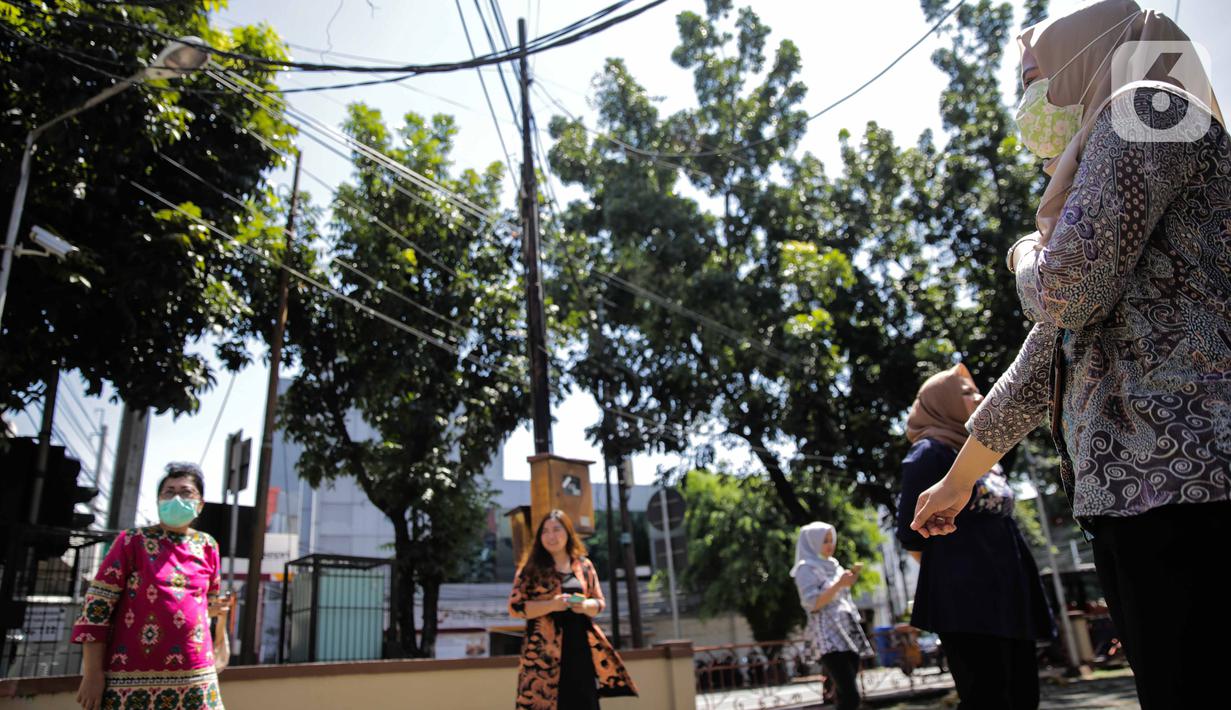 Sejumlah pegawai berjemur di bawah sinar matahari di Kawasan Fatmawati, Jakarta, Selasa (31/3/2020). Berjemur diri di bawah sinar matahari saat pagi merupakan salah satu upaya yang paling sederhana untuk menjaga kesehatan selama wabah virus COVID-19. (Liputan6.com/Faizal Fanani)