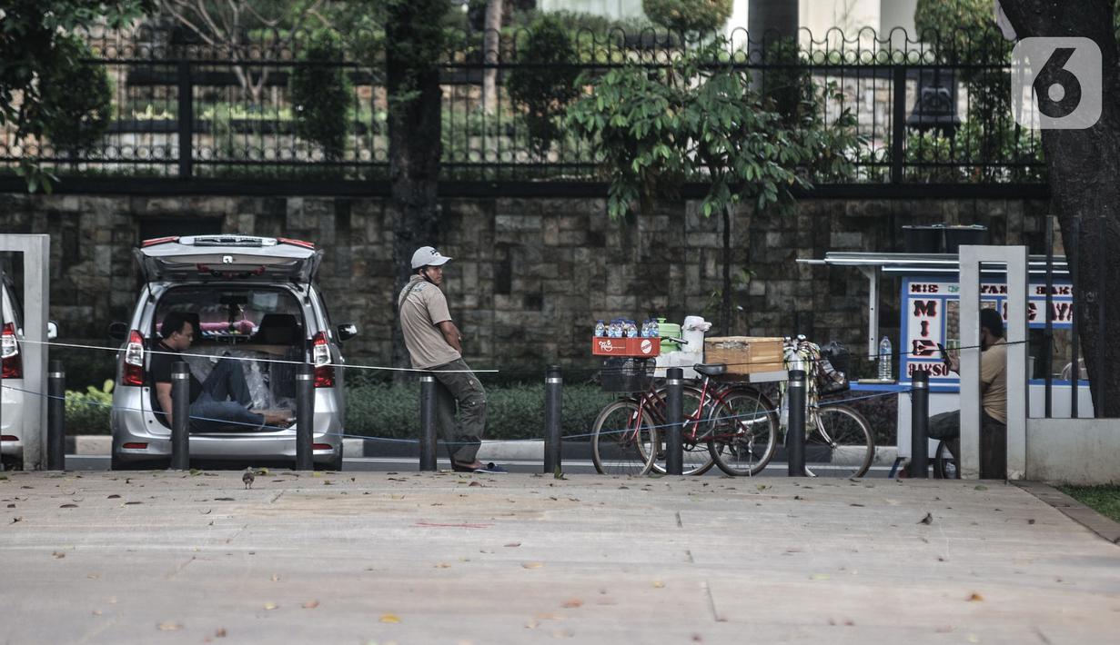 Pedagang menunggu pembeli di depan Lapangan Banteng, Jakarta, Kamis (15/9/2020). Lapangan Banteng dan hutan kota lainnya di Ibu Kota Kembali ditutup sementara selama penerapan pembatasan sosial berskala besar (PSBB) Jakarta guna menekan penyebaran Covid-19 di ruang publik (merdeka.com/Iqbal Nugroho)