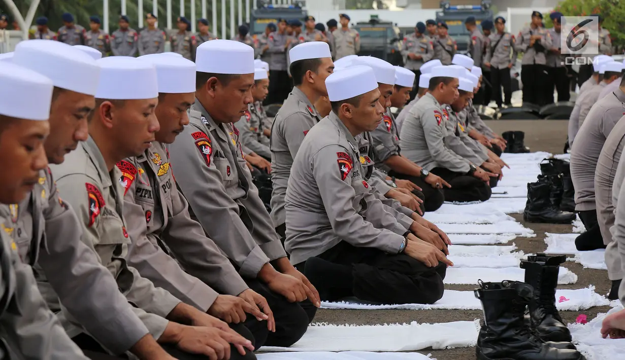 Personel Brimob yang tergabung dalam Pasukan Dzikir Asmaul Husna melakukan salat di depan Gedung MPR/DPR, Senayan, Jakarta, Selasa (24/10). Sebanyak 299 personel dikerahkan untuk menjaga demo menolak Perppu Ormas di gedung DPR. (Liputan6.com/JohanTallo)