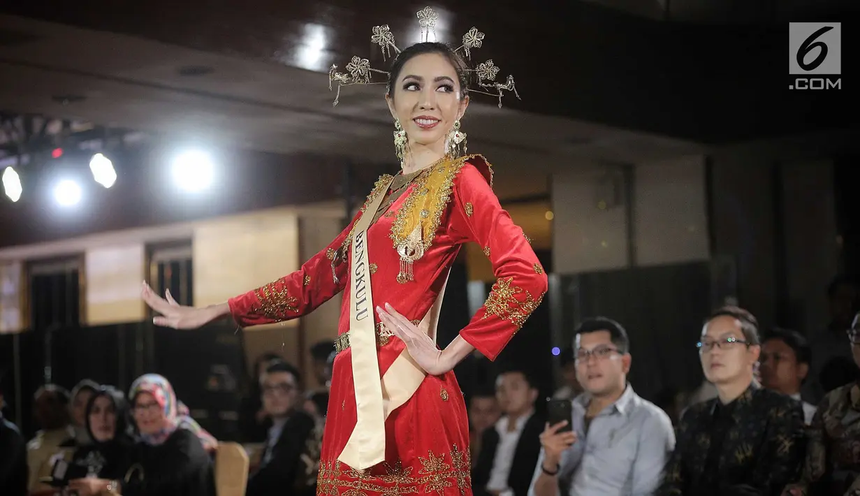 Finalis Bengkulu, Nadia Purwoko menampilkan bakat dalam balutan busana tradisional dari daerahnya saat babak preliminary Miss Grand Indonesia 2018 di Jakarta, Senin (16/7). Sebanyak 30 finalis mencapai babak preliminary. (Liputan6.com/Faizal Fanani)