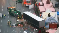 Petugas menderek truk yang menabrak Pasar Natal di Berlin, Jerman, Selasa (20/12). Akibat kejadian ini, dikabarkan 12 orang tewas dan 48 orang terluka. (REUTERS / Fabrizio Bensch)