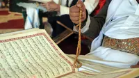 Pria Muslim menggunakan tasbih saat membaca Al-qur'an pada hari pertama bulan suci Ramadhan di Masjid Al-Kabir di kota tua Sanaa, ibu kota Yaman, 2 April 2022. Pada bulan Ramadhan umat muslim memanfaatkan waktu untuk memperbanyak ibadah dengan membaca Al Quran. (MOHAMMED HUWAIS/AFP)